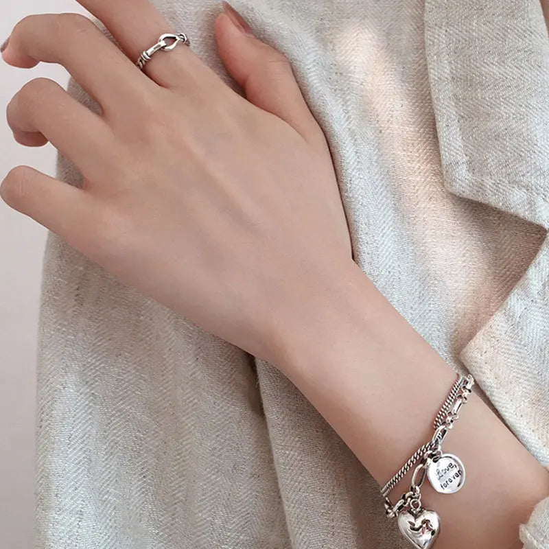 Sterling silver heart charm bracelet with ‘Love forever’ engraved tag”
