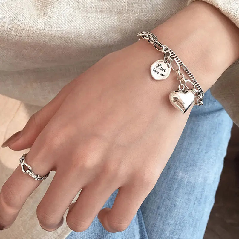 Sterling silver heart charm bracelet with ‘Love forever’ engraved tag”
