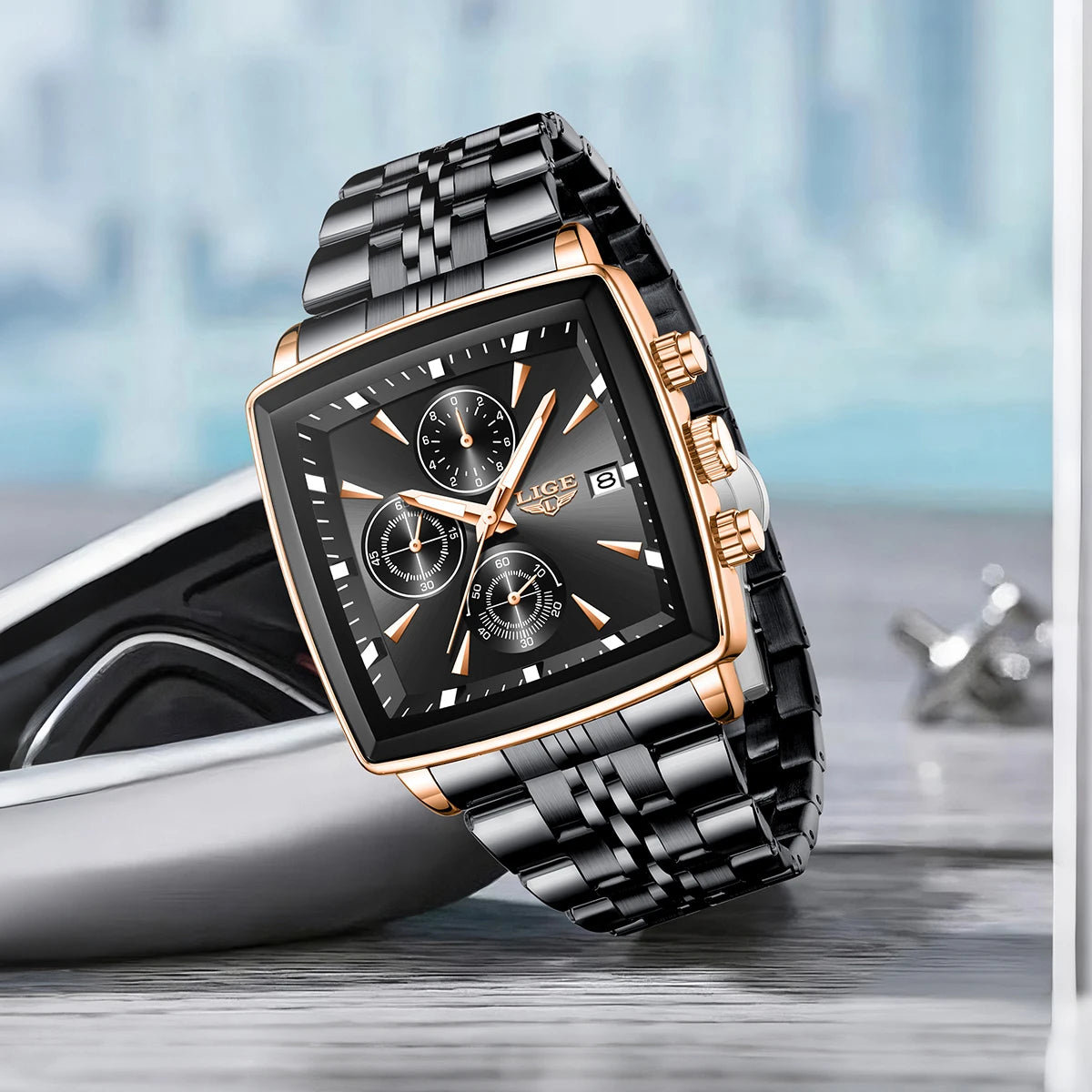 Luxury men’s square chronograph watch with black dial, gold case, and two-tone stainless steel bracelet”