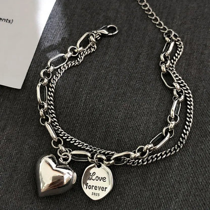Sterling silver heart charm bracelet with ‘Love forever’ engraved tag”