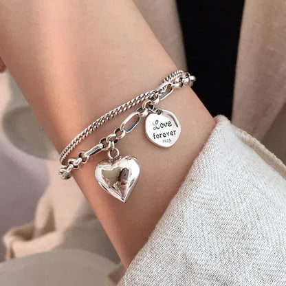 Sterling silver heart charm bracelet with ‘Love forever’ engraved tag”