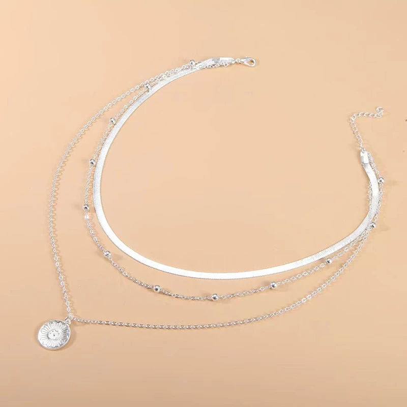 Layered silver necklace set with sun pendant and minimalist chains