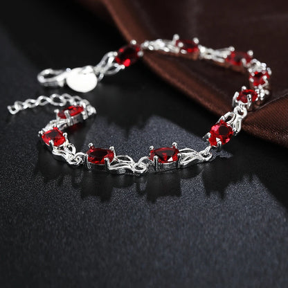 Silver plated bracelet with ruby red gemstones – elegant filigree design